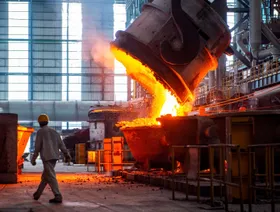 عامل يسير بجانب فولاذ منصهر داخل مصنع للصلب في مقاطعة جيانغسو الصينية - Getty Images