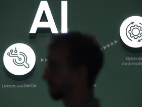 شخص يعبر من أمام لوحة تشرح بعض المعلومات عن الذكاء الاصطناعي - المصدر: بلومبرغ