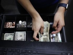 موظفة ترتب رزماً نقدية من الدولار داخل متجر بمدينة لويفيل بولاية كنتاكي، أميركا - بلومبرغ