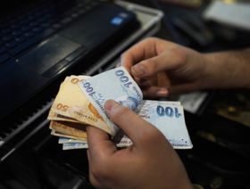 موظف يعد أوراقاً نقدية من الليرة التركية - بلومبرغ