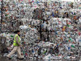 أحد موظفي مصنع "Closed Loop Recycling" يسير بجوار أكوام من نفايات الزجاجات البلاستيكية في داغنهام، لندن، المملكة المتحدة - الشرق/بلومبرغ