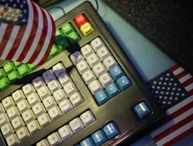 لوحة مفاتيح يرفرف فوقها العلم الأميركي - بلومبرغ