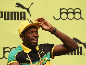 العداء الجامايكي يوسين بولت ويظهر خلفه شعار شركة "بوما" للملابس والأحذية الرياضية - Getty Images