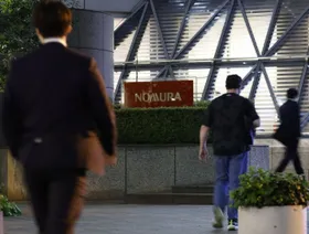 أشخاص يمرون بجوار مقر "نومورا هولدينغز" الرئيسي في طوكيو، اليابان - المصدر: بلومبرغ