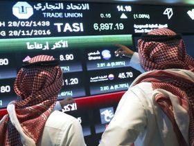 مستثمران يتابعان تحركات الأسهم المعروضة على شاشات الفيديو الكبيرة داخل السوق المالية السعودية، في الرياض، المملكة العربية السعودية (صورة أرشيفية) - المصدر: بلومبرغ