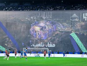 مباراة لنادي الهلال وتظهر في الخلفية صورة "استاد الأمير محمد بن سلمان" في القدية ويتوسطها شعار "معاً نلعب" - منصة "X"