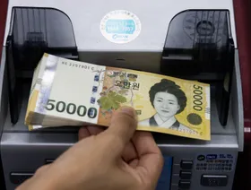 ورقة نقدية من فئة 50 ألف وون كوري جنوبي تمر عبر آلة عد للنقود - بلومبرغ