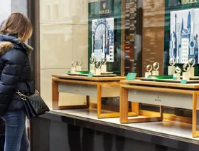 متسوقتان تتأملان ساعات 'رولكس' الفاخرة من نافذة متجر - المصدر: بلومبرغ