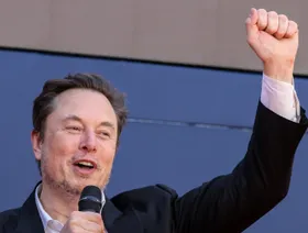 إيلون ماسك، الرئيس التنفيذي لـ"تسلا"، يرفع قبضة يديه خلال تجمع "أتريجو" بروما، إيطاليا، بتاريخ 16 ديسمبر 2023 - المصدر: بلومبرغ