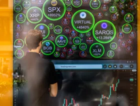 شاب ينظر إلى شاشة تعرض أسعار العديد من العملات الرقمية والمشفرة - بلومبرغ