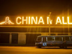 حافلة صغيرة متوقفة أمام مبنى تجاري تعلوه لافتة مضيئة باسم "تشاينا مول" مزينة برسومات سور الصين العظيم في كيتوي في زامبيا - المصدر: بلومبرغ