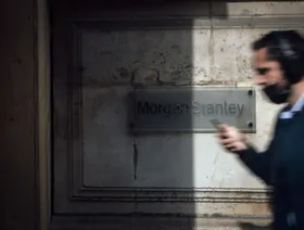 شخص يمر أمام لافتة خارج مكاتب مورغان ستانلي، في باريس، فرنسا - المصدر: بلومبرغ