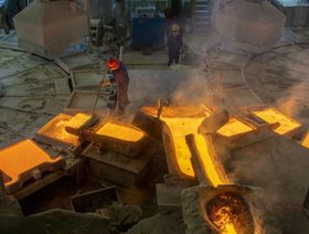 عمال يملئون هياكل معدنية بالحديد المنصهر في منشأة صناعية  - المصدر: غيتي إيمجز