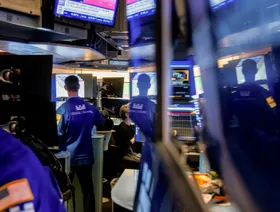 متداول في بورصة نيويورك للأوراق المالية وانعكاس صورته، في نيويورك، الولايات المتحدة الأميركية - بلومبرغ