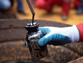 عامل يجمع عينة من النفط الخام - المصدر: بلومبرغ