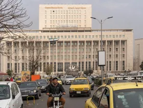 صورة من وسط العاصمة السورية دمشق تظهر سيارات وفي الخلف مقر مصرف سورية المركزي وعليه العلم الجديد للبلاد - بلومبرغ