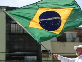 الرئيس البرازيلي لويس إيناسيو لولا دا سيلفا يلوح بعلم خلال تجمع انتخابي - المصدر: بلومبرغ