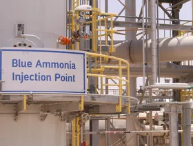 لافتة مكتوب عليها "نقطة حقن الأمونيا الزرقاء" في منشأة صناعية كبيرة كما توجد كاميرا مراقبة مثبتة على أحد الأعمدة - بلومبرغ