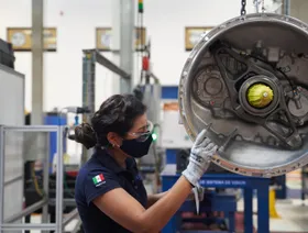 عاملة تتفحص قطعة ميكانيكية لمركبة ثقيلة داخل مصنع للمركبات في مكسيكو سيتي، المكسيك - بلومبرغ