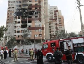 رجال إطفاء بالقرب من مبنى متضرر في أعقاب الغارات الإسرائيلية على طهران. 13 يونيو 2025 - رويترز 