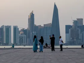 زوار يلتقطون الصور مقابل مركز قطر المالي في الدوحة، قطر، الاثنين 19 مايو 2025 - بلومبرغ