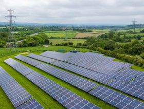 أبراج كهرباء إلى جانب ألواح شمسية في مزرعة للطاقة الشمسية بالقرب من تشيسترفيلد، المملكة المتحدة، يوم الإثنين 20 مايو 2024 - بلومبرغ