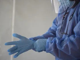 طبيب يرتدي ملابس واقية قبل الشروع في مهام عمله. ساعد الذكاء الاصطناعي متخصصي الرعاية الصحية في تحسين القدرة على اكتشاف أورام ما قبل السرطان في القولون، لكن عند وقف الاستعانة بالمساعدة، انخفضت قدرتهم على اكتشاف الأورام بنحو 20% مقارنةً بمعدلات ما قبل بدء استخدام الأداة. - بلومبرغ