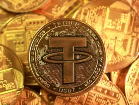 مسكوكة رمزية تحمل شعار العملة المستقرة "تيذر" - رويترز 