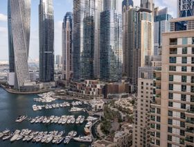 صورة بانورامية لمرسى دبي تظهر أبراجاً شاهقة عصرية تحيط بمرسى مليء باليخوت الفاخرة. - بلومبرغ