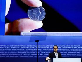 مارتن شليغل، رئيس المصرف الوطني السويسري (SNB)، يستعرض قطعة نقدية خلال الاجتماع العام السنوي للمصرف الوطني السويسري في برن، سويسرا، يوم الجمعة 25 أبريل 2025. - بلومبرغ