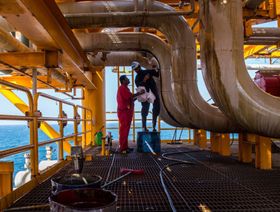 عمال يقومون بتنظيف تسرب النفط من الأنابيب على متن منصة نفط بحرية في حقل سلمان للنفط في الخليج العربي، الذي تديره شركة النفط البحرية الوطنية الإيرانية، بالقرب من جزيرة لافان، إيران - المصدر: بلومبرغ