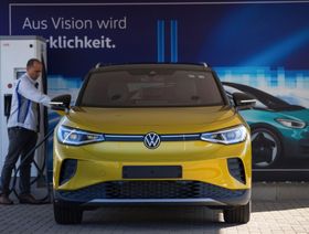 موظف يقوم بتوصيل سيارة فولكس فاجن ID.4 كروس أوفر كهربائية في مصنع بألمانيا - المصدر: بلومبرغ