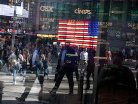 أشخاص يمرون أمام بورصة "ناسداك" وشاشات تعرض مؤشرات الأسهم،  في نيويورك، الولايات المتحدة - المصدر: بلومبرغ