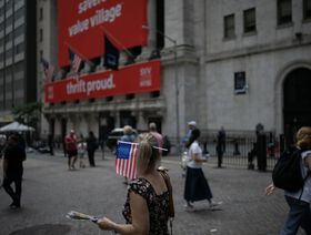 سيدة تزين شعرها بالعلم الأميركي بالقرب من بورصة نيويورك (NYSE) في نيويورك، الولايات المتحدة، يوم الخميس 29 يونيو 2023.  - المصدر: بلومبرغ