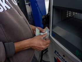 عميل يقوم بسحب أموال من آلة سحب تابعة لأحد البنوك في بيروت. - المصدر: بلومبرغ