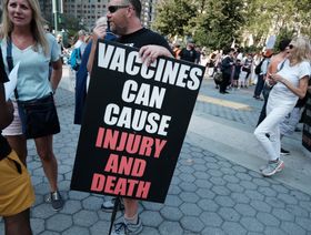 متظاهرون يحملون لافتات تحوي عبارات مناهضة للتطعيم ضد كوفيد. - المصدر: بلومبرغ