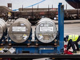 عامل يثبت إسطوانات اليورانيوم على شاحنة نقل - المصدر: بلومبرغ