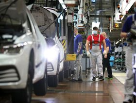 موظفون يراقبون خط إنتاج سيارات في مصنع فولكس واجن في فولفسبورغ بألمانيا - المصدر: بلومبرغ