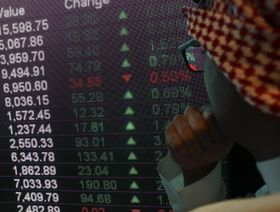 رجل يطالع لوحة إلكترونية تعرض أسعار أسهم داخل سوق الأسهم السعودية (صورة أرشيفية) - المصدر: بلومبرغ
