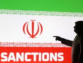 نموذج مصغّر مطبوع بتقنية الطباعة ثلاثية الأبعاد يُظهر الرئيس الأميركي دونالد ترمب، وعلم إيران، وكلمة "Sanctions" (العقوبات). - رويترز 