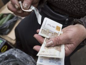 شخص يحمل نقود من فئة خمسة وعشرة روبل روسي - المصدر: بلومبرغ