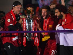 يورغن كلوب، وآدم لالانا، ومحمد صلاح يحملون كأس الدوري الإنجليزي احتفالاً بالفوز باللقب، بعد التغلب على نادي "تشيلسي" في موسم 2020، على ملعب "أنفيلد" في ليفربول، إنجلترا.  - المصدر: غيتي إيمجز