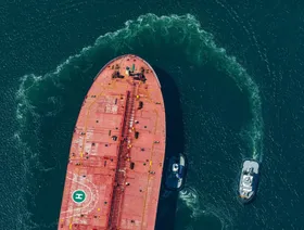 ناقلة نفط تبحر في المياه إلى جانب قاربين أصغر حجماً - المصدر: بلومبرغ