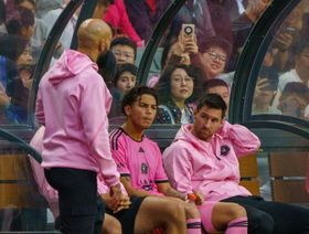 ليونيل ميسي (يميناً) على مقعد البدلاء في أثناء مباراة "إنتر ميامي" في هونغ كونغ - المصدر: بلومبرغ