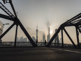 مشاة على جسر قبالة الحي المالي في شنغهاي، الصين - المصدر: بلومبرغ