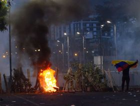 متظاهر يحمل علم الإكوادور  أثناء احتجاج حركة عمال الأراضي الأصليين في كيتو، الإكوادور. - المصدر: بلومبرغ