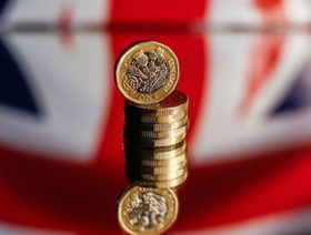كومة من العملات الجنيه الاسترليني أمام علم الاتحاد البريطاني ، ، في هذه الصورة المرتبة في لندن ، المملكة المتحدة ، يوم الأربعاء ، 14 أكتوبر ، 2020. - المصدر: بلومبرغ