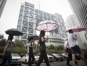 مارة أمام مبنى بورصة شنغهاي للأوراق المالية، شنغهاي، الصين - المصدر: بلومبرغ