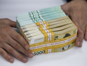 شخص يمسك برزم من الأوراق النقدية لعملة الوون الكورية الجنوبية فئة 5000 وون - المصدر: بلومبرغ