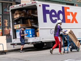 سائق متعاقد مستقل لشركة "فيديكس" بقوم بمسح الطرود خارج شاحنة في سان فرانسيسكو، كاليفورنيا، الولايات المتحدة - المصدر: بلومبرغ